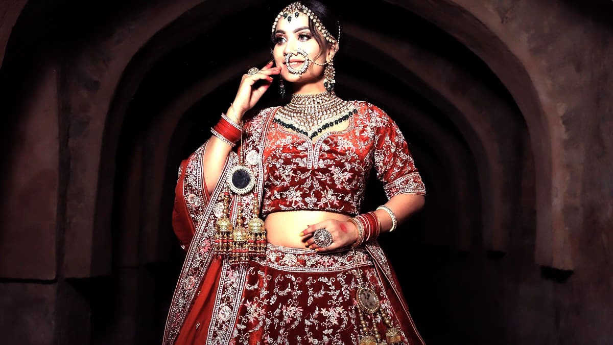 A Sri Sakhi client in a deep plum hand-worked lehenga, photographed in the atelier